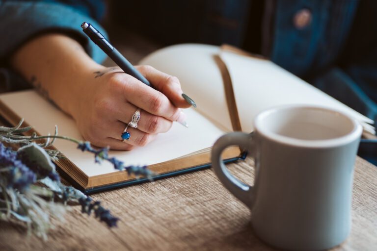 Female hand writing in a journal for writing therapy